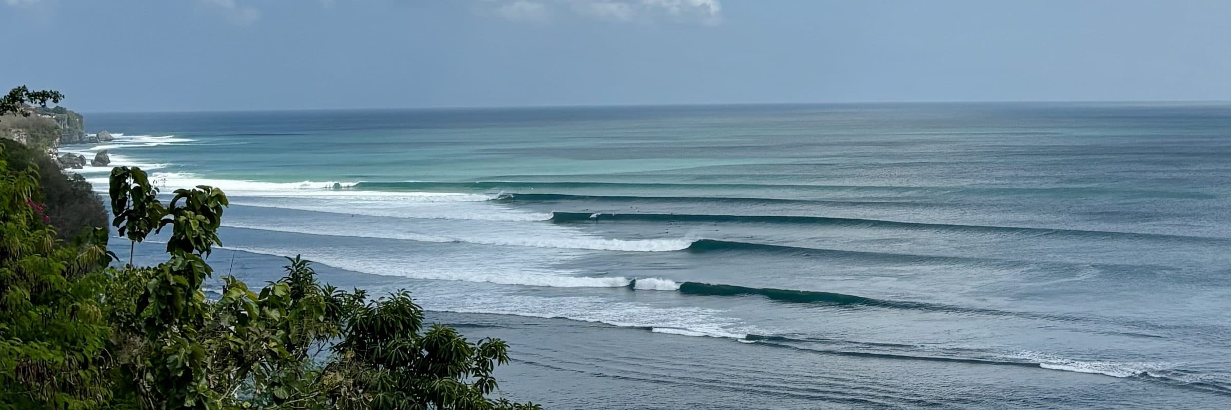 A surfer riding a long open face at Impossibles